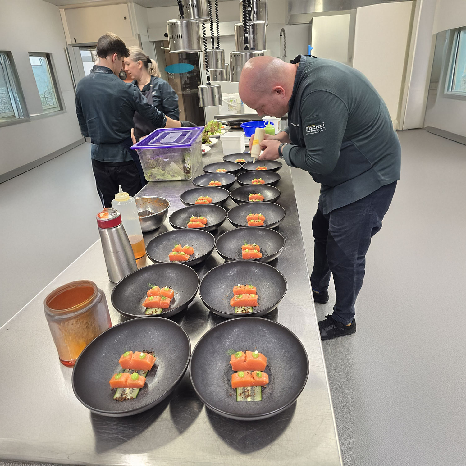 Ob als Teamevent, mit Freunden oder als besondere Feier – in Toms Genusswerkstatt wird Kochen zum unvergesslichen Erlebnis. In Gruppen von 6 bis 14 Personen taucht ihr gemeinsam in die Welt der Kulinarik ein und kreiert unter fachkundiger Anleitung ein mehrgängiges Menü. Hier steht nicht nur das Ergebnis im Mittelpunkt, sondern vor allem der Weg dorthin: schnippeln, rühren, lachen, abschmecken – und als Team zusammenwachsen. Unser Erlebnis-Cooking verbindet Genuss mit Kommunikation, Kreativität und jeder Menge Spaß. Perfekt geeignet für Firmen, Vereine oder private Gruppen, die etwas Besonderes erleben möchten. Am Ende genießt ihr eure selbst zubereiteten Köstlichkeiten in entspannter Atmosphäre – begleitet von guten Gesprächen und einem Glas Wein. Euer Event. Euer Menü. Euer gemeinsames Erlebnis. Jetzt Termin sichern und Genuss neu erleben!